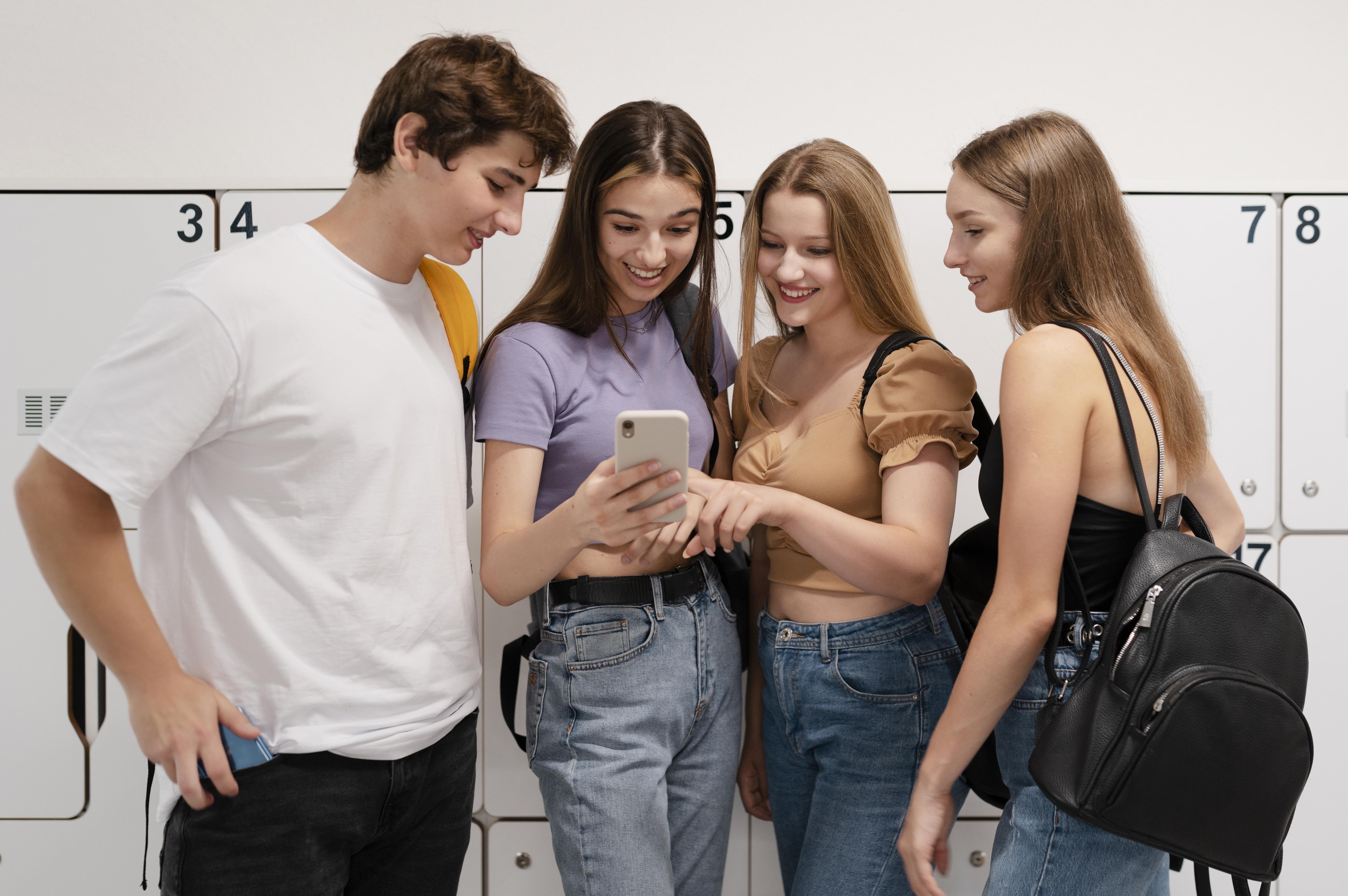 Lycéens de terminale consultant un téléphone